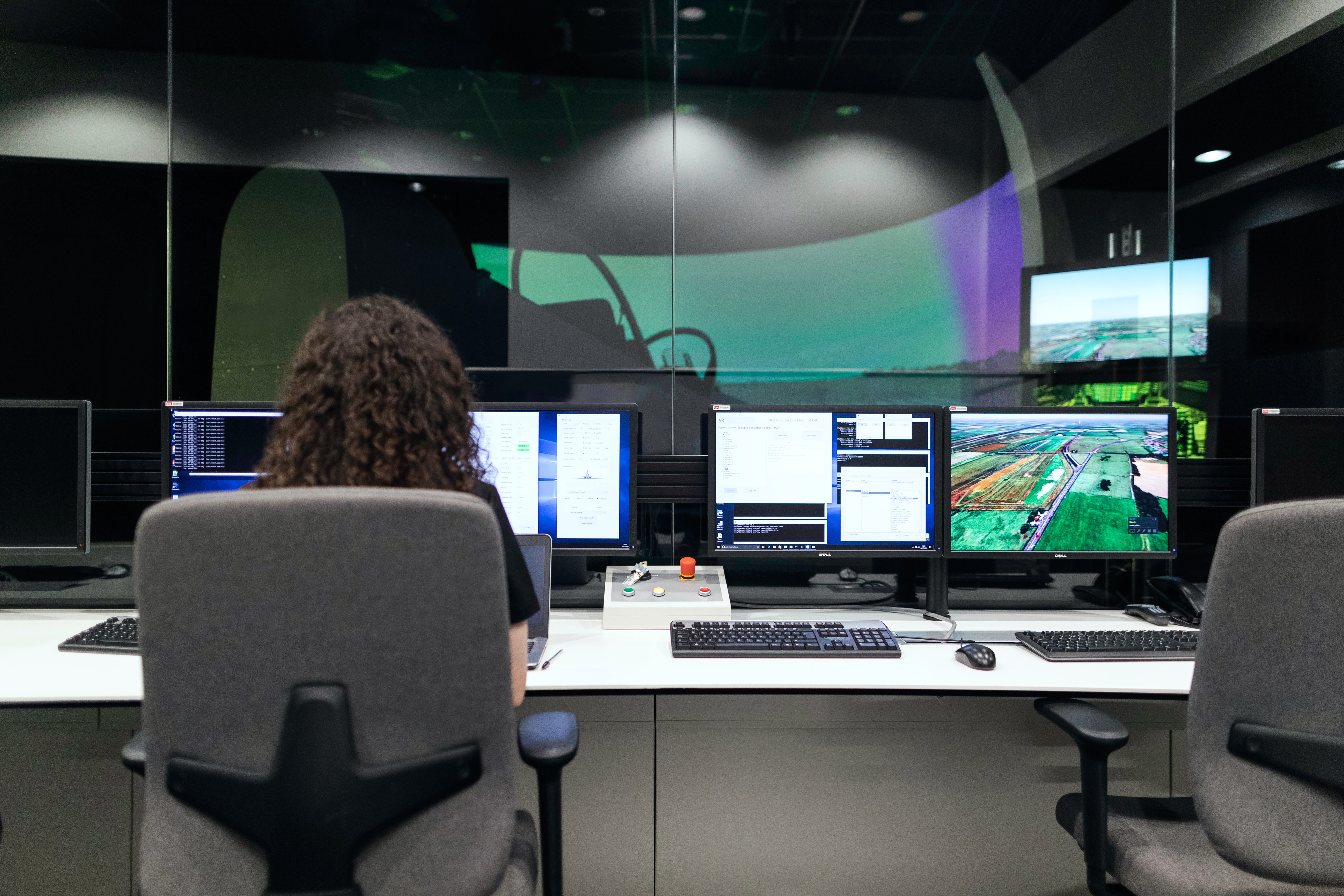 Woman looking at multiple computer screens in an office